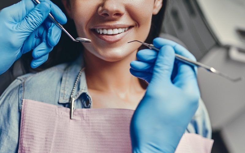 Young lady smiles having her teeth checked by the dentist. Medazur Medical Clinic in Leytonstone.