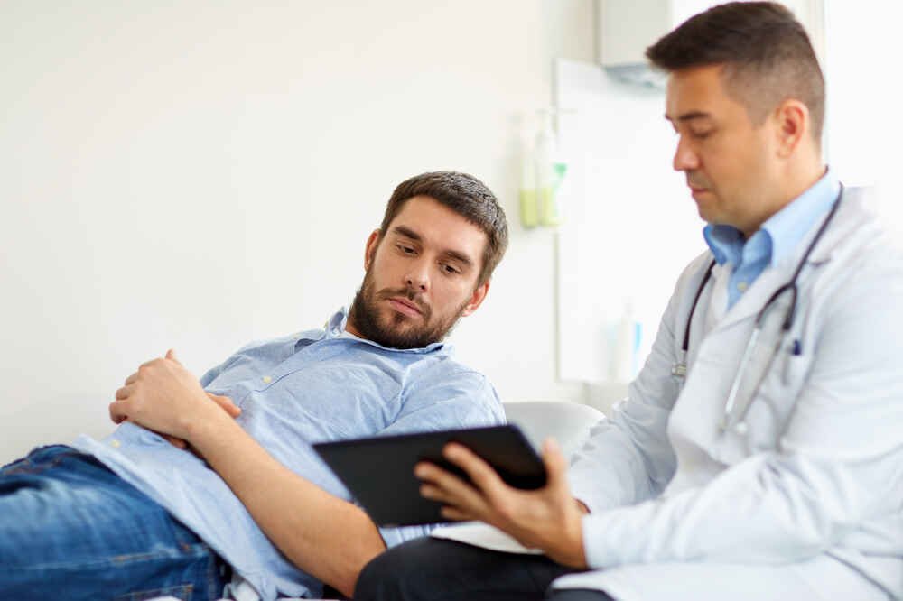 Male doctor with male patient explains about the upcoming treatment. Medazur Medical Clinic in Leytonstone.
