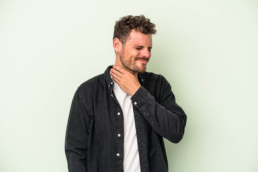 Young caucasian man suffers from throat pain. Medazur Medical Clinic in Leytonstone.